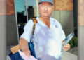 Male letter carrier on sidewalk