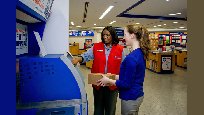 Employee in red vest assists customer