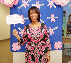 Woman stands in front of breast cancer awareness display
