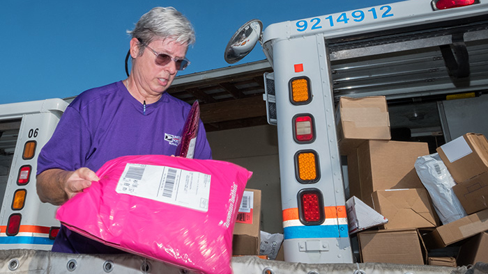 Woman loads mail truck