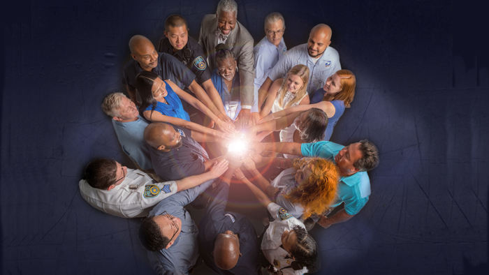 Circle of people with hands in center