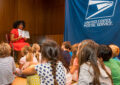 Woman reads to young children in library