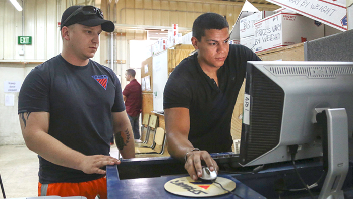 Two men look at computer