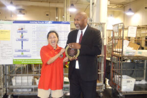 Woman receives trophy from man