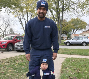 USPS letter carrier and child wearing letter carrier's costume
