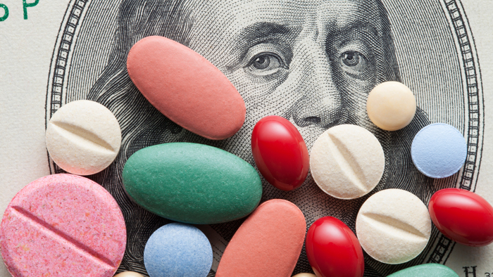 Colorful pills over a Ben Franklin bill