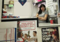 Worker stands behind Post Office counter