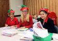 Three employees dressed as Santa's elves