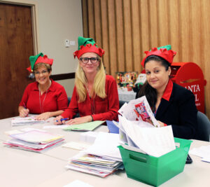 Three employees dressed as Santa's elves