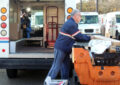 TV cameraman films man loading delivery vehicle