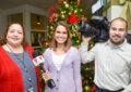 Woman stands with TV report and cameraman