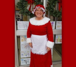Woman dressed as Mrs. Claus smiles