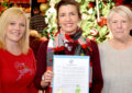 Three women hold letter