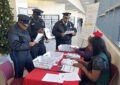 Police officers talking to postal employees in retail setting