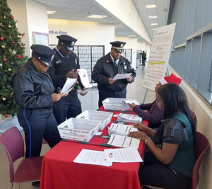 Police officers talking to postal employees in retail setting