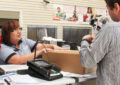 Postal worker serving customer at counter