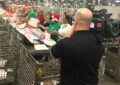 TV cameraman films postal workers on assembly line