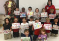 Children hold up letters