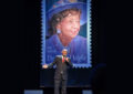 Man sings in front of Dorothy Height stamp image