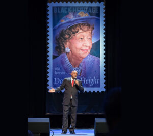 Man sings in front of Dorothy Height stamp image