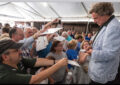 Man autographs programs among large crowd