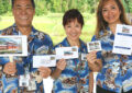 Three people hold envelopes and stamps