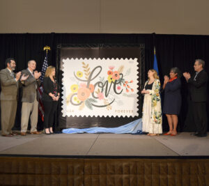 Ceremony participants unveil the Love stamp
