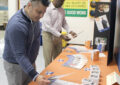 Two men look at brochures on table