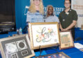 Three postal employees stand at booth