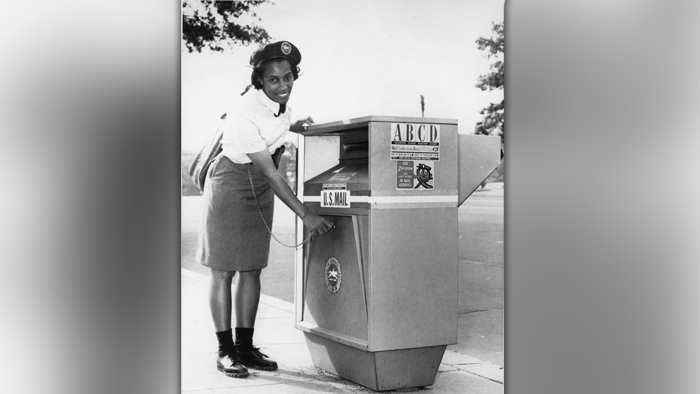 Woman places mail in mailbox