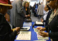 Postal workers sell stamps to customers at booth