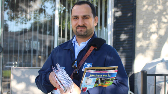 Letter carrier holds mail