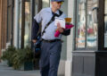 Letter carrier walks down sidewalk