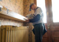 Letter carrier delivers mail inside quaint apartment building