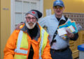 Letter carrier places arm around smiling man