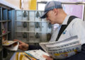 Letter carrier places mail inside box