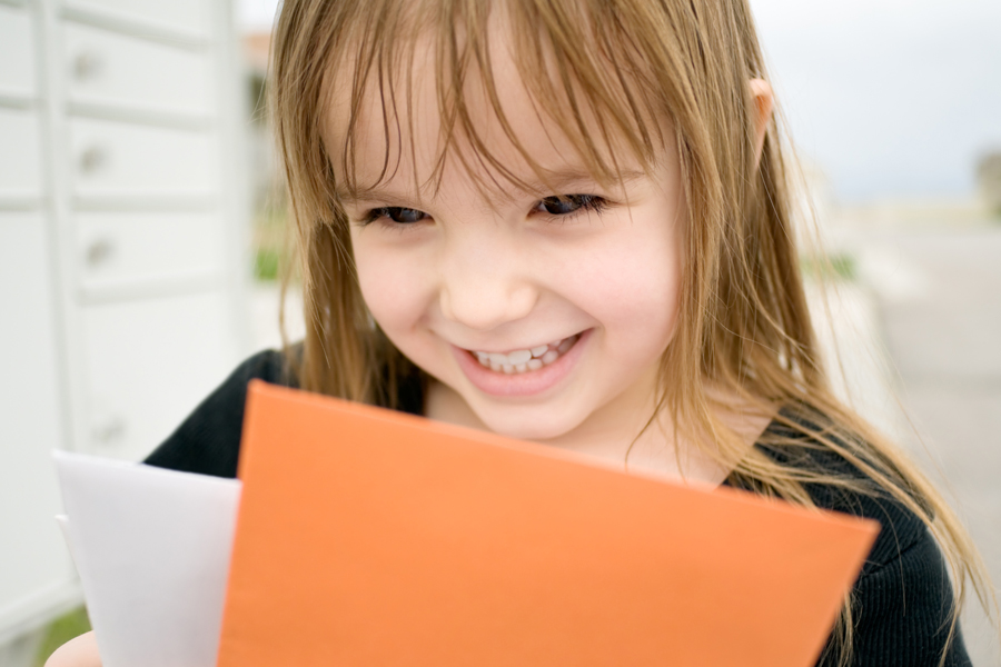 Smiling child holding envelopes