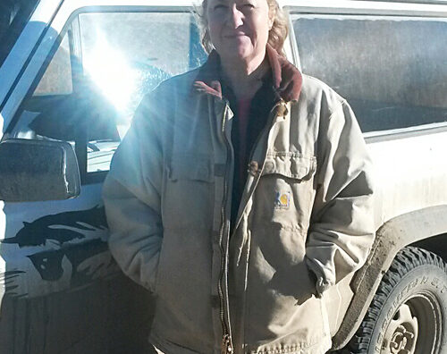 Woman stands next to vehicle