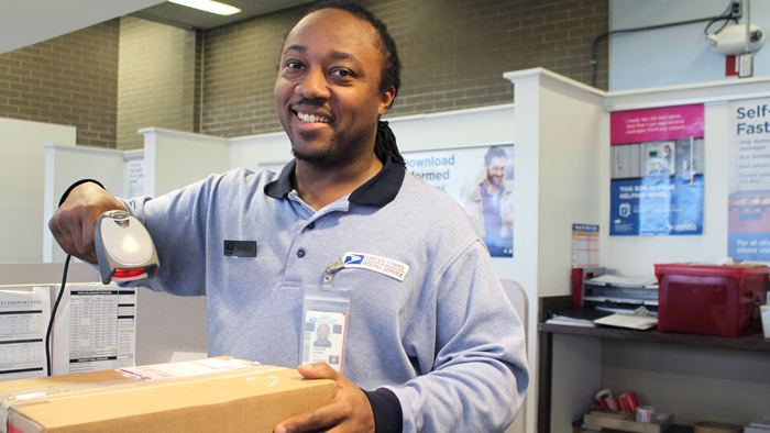 Smiling employee scans package