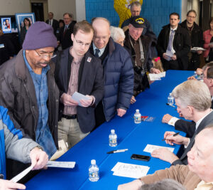 People line up at table for autographs
