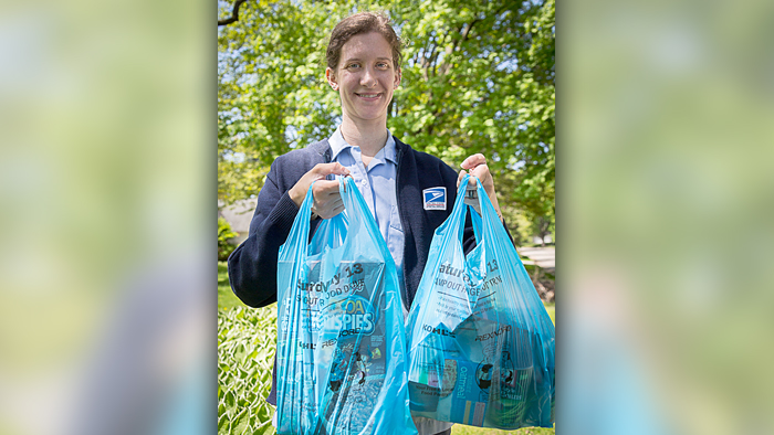 Letter carrier holding food donations