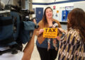 Woman speaks to TV reporter and cameraman in Post Office lobby