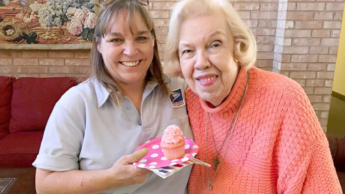 Two women holding cupcake