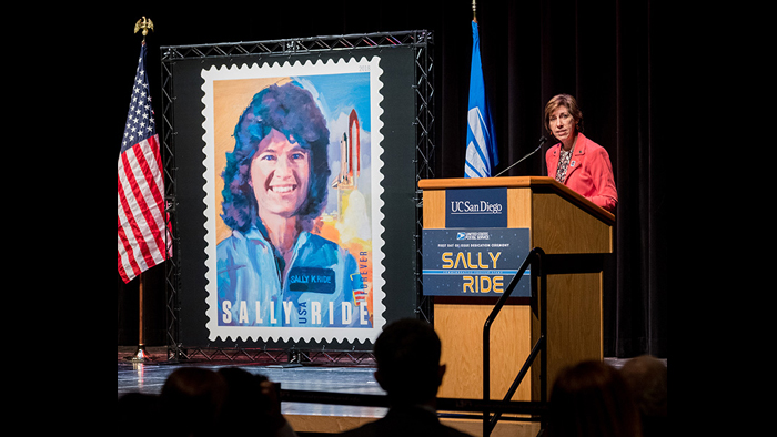 Sally Ride stamp banner with woman at podium