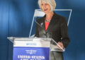 Woman stands at podium speaking