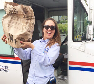 Postal worker holds up brown paper bag