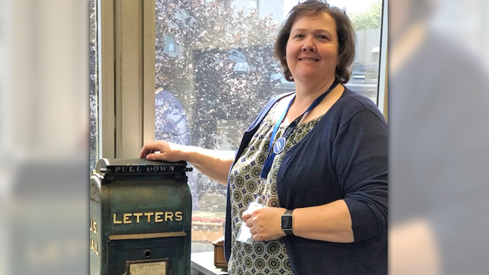 Administrative Assistant Rebecca Brundidge with vintage mailbox