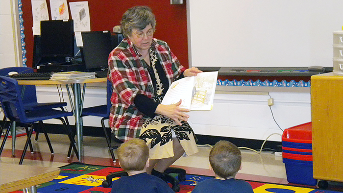Woman reading to students
