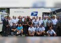 Postal workers pose in front of delivery vehicle