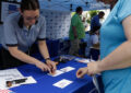 Postal worker handles customer transaction at booth